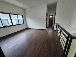 Spacious bedroom with wooden flooring and hallway