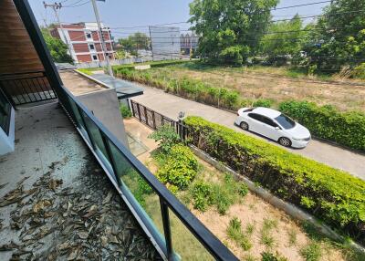 View from the balcony overlooking a street and greenery