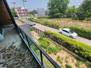 View from the balcony overlooking a street and greenery