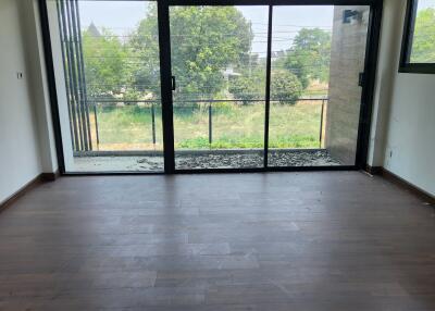 Spacious living room with large glass doors leading to an outdoor view