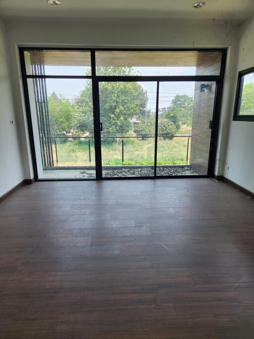 Spacious living room with large glass doors leading to an outdoor view