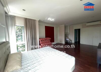 Spacious bedroom with a large bed, seating area, and ample natural light.