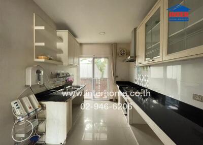 modern kitchen with white cabinetry and black countertops