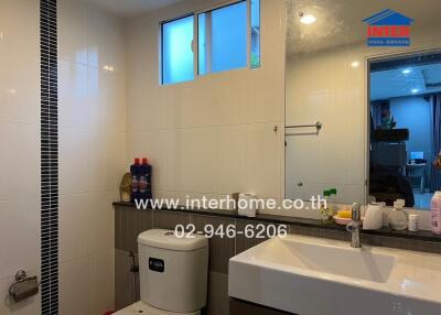 Modern bathroom with a sink, toilet, and toiletries