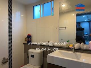 Modern bathroom with a sink, toilet, and toiletries