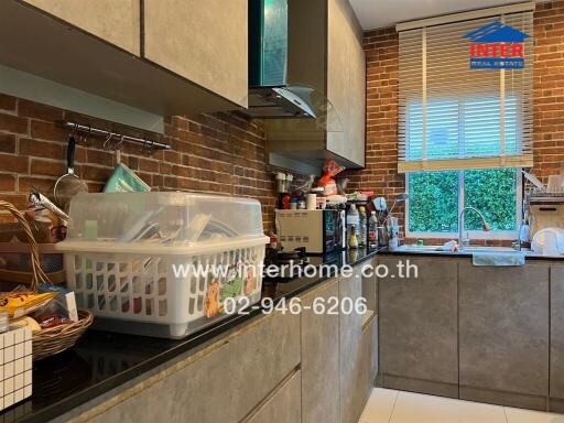 modern kitchen with various appliances and a brick wall