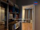 Hallway with bookshelf and view into the bedroom