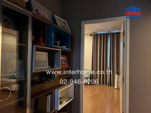 Hallway with bookshelf and view into the bedroom