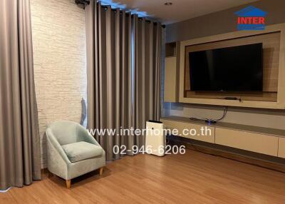 Modern living room with large TV and comfortable seating
