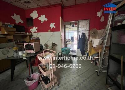 Kitchen with red walls and various items scattered around