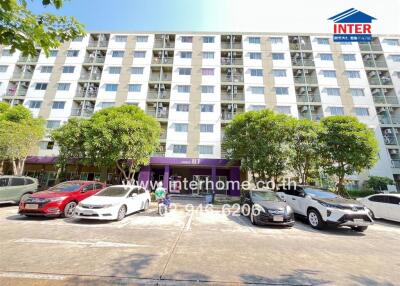 Exterior view of multi-story residential building with parked cars in front