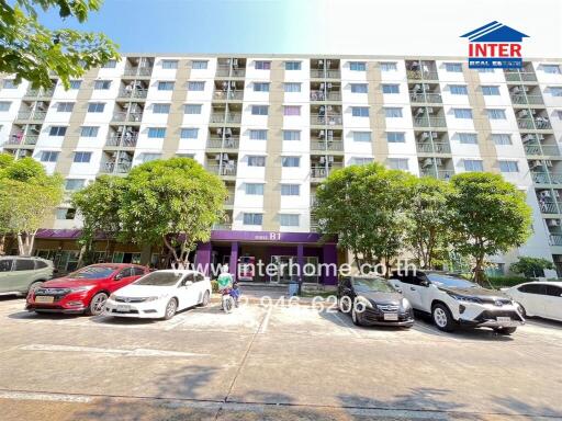 Exterior view of multi-story residential building with parked cars in front