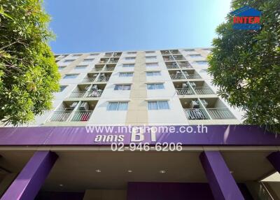 Facade of a multi-story residential building with balconies and trees