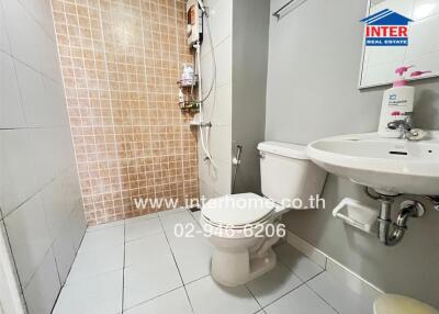 Modern bathroom with tiled shower, toilet and sink