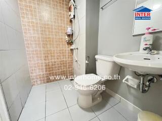 Modern bathroom with tiled shower, toilet and sink