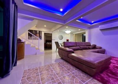 Modern living room with stylish purple lighting and leather sectional sofa