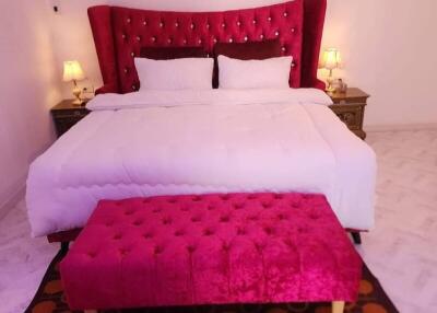 Luxury bedroom with a red tufted headboard and matching bench