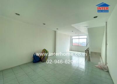 Empty living room with large window and tile flooring