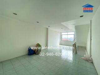 Empty living room with large window and tile flooring