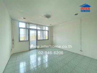 Empty room with tiled flooring and large windows