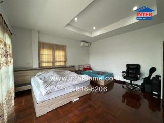 Spacious bedroom with wooden flooring and ample natural light