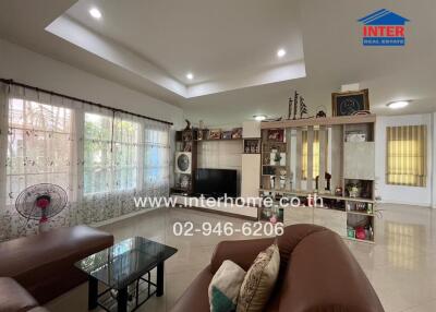 Spacious living room with sofa, shelving, and large windows