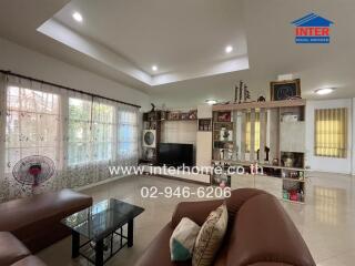 Spacious living room with sofa, shelving, and large windows