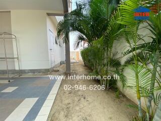Outdoor view of property with tiled walkway and garden area
