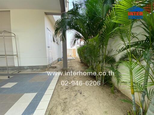 Outdoor view of property with tiled walkway and garden area