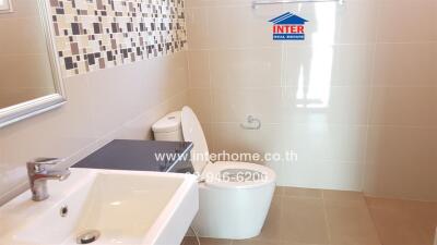 Modern bathroom with sink, toilet, and decorative tiles