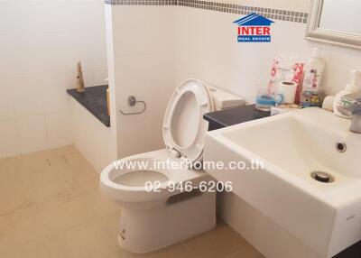Bathroom with sink, toilet, and various toiletries