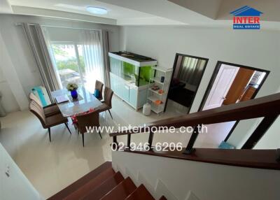 Modern living area with dining table and view of the outside through large glass doors