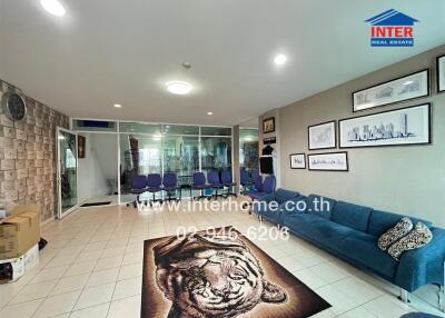Living room with blue sofa, tiger rug, and wall art