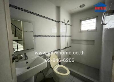 Bathroom with sink, mirror, toilet, and shower area