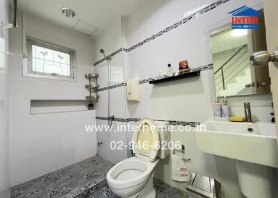 Modern bathroom with toilet, sink, and shower area