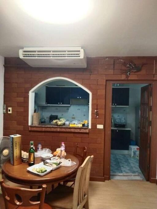 Dining area with table, chairs, and view into kitchen