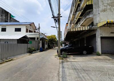 Street view showing surrounding buildings and parked cars