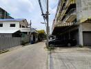 Street view showing surrounding buildings and parked cars