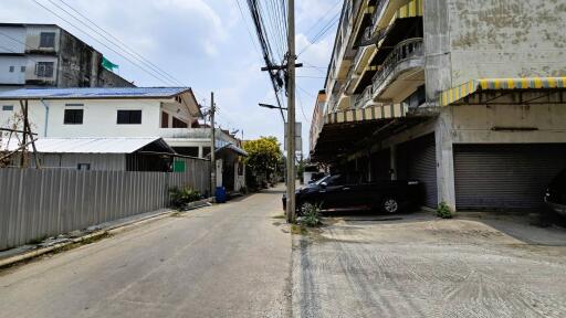 Street view showing surrounding buildings and parked cars