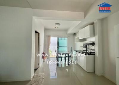 Modern kitchen and dining area with white cabinets and glossy tiled floor.