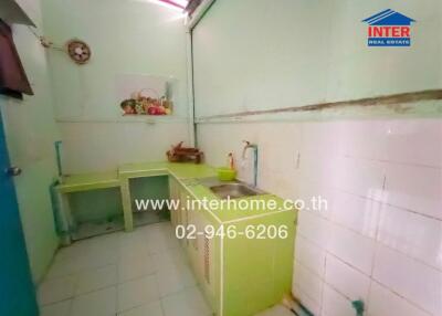 Small kitchen with green cabinets and sink