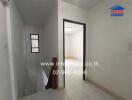 Minimalist hallway with stair access and view into a room