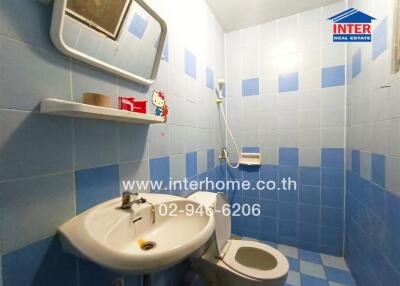 Blue-tiled bathroom with sink, toilet, and shower