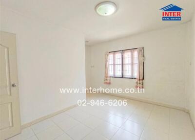 Empty bedroom with a window and curtain, white tiled floor