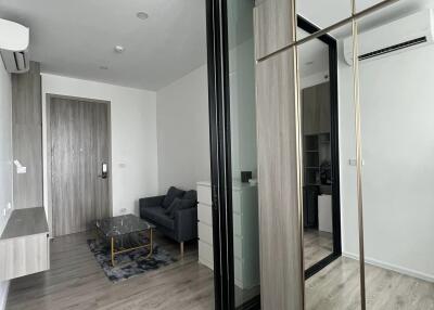 Modern apartment with wooden flooring, glass partition, and mirrored closet