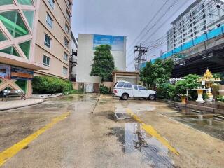 Exterior view of residential buildings with parking area on a rainy day