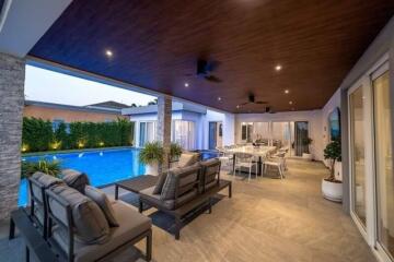 Spacious outdoor patio with seating and dining area overlooking a swimming pool