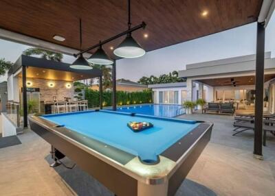 Outdoor leisure area with pool table, swimming pool, and lounge seating