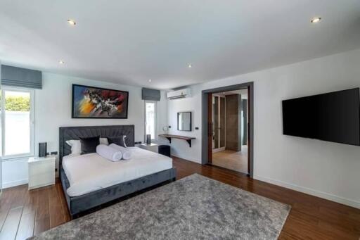 Modern bedroom with bed, TV, and en-suite bathroom