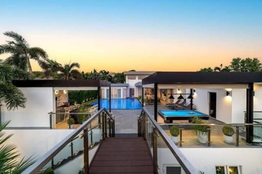 Modern outdoor area with pool and recreational spaces at sunset